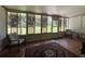 Light-filled sunroom featuring wood floors, area rug, and expansive views of backyard at 1523 Se 80Th St, Ocala, FL 34480