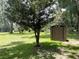 Landscaped backyard with storage shed and mature trees at 1523 Se 80Th St, Ocala, FL 34480