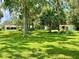Expansive backyard with lush green grass and mature trees and outbuildings at 1523 Se 80Th St, Ocala, FL 34480