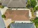 A high-angle aerial view showcasing the property's roof, patio, and adjacent landscaped yard at 1751 Brandenburg Ct, The Villages, FL 32163