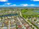 Community aerial view showcasing the neighborhood's lush landscaping, golf course, and picturesque pond at 1751 Brandenburg Ct, The Villages, FL 32163