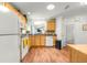 Bright kitchen with wooden cabinets, white appliances, and hardwood-style floors at 1751 Brandenburg Ct, The Villages, FL 32163
