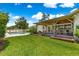 A backyard featuring a covered patio, green grass, and a pool at 1922 Se 13Th St, Ocala, FL 34471