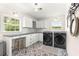Well-lit laundry room with modern black washer and dryer units and stylish patterned flooring at 1922 Se 13Th St, Ocala, FL 34471