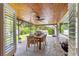 An outdoor patio area featuring a wooden ceiling, a dining table, and a grill at 1922 Se 13Th St, Ocala, FL 34471
