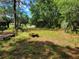 Large backyard featuring grassy area, mature trees, a swing set and firepit at 20045 Sw 88Th Place Rd, Dunnellon, FL 34431