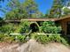 Front entrance featuring a trellised walkway and lush foliage, bench, and front door at 20045 Sw 88Th Place Rd, Dunnellon, FL 34431