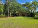 The front entrance features a trellised walkway and lush foliage with a pathway to the front door at 20045 Sw 88Th Place Rd, Dunnellon, FL 34431