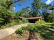 Quaint single-story home featuring an attached two-car garage, driveway, and mature trees surrounding the property at 20045 Sw 88Th Place Rd, Dunnellon, FL 34431