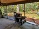 View of the home's patio featuring a grill, fans, and scenic views of the backyard with a swing set at 20045 Sw 88Th Place Rd, Dunnellon, FL 34431