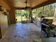 View of the home's tiled patio featuring a ceiling fan, grill, and views of the backyard at 20045 Sw 88Th Place Rd, Dunnellon, FL 34431
