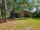 View of the back of the home featuring a screened porch and mature trees at 20045 Sw 88Th Place Rd, Dunnellon, FL 34431