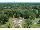 Aerial view of a cozy home with a fenced pool surrounded by lush greenery and trees at 2340 Ne 14Th Ave, Ocala, FL 34470