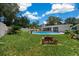 Backyard features in ground pool, fire pit, grill, lush landscaping, and privacy fence at 2340 Ne 14Th Ave, Ocala, FL 34470