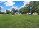 Expansive grassy yard with a white single-story house, storage, and serene country atmosphere at 2340 Ne 14Th Ave, Ocala, FL 34470