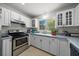 Bright kitchen with white cabinets, stainless steel appliances, and a view of the greenery outside the window at 2340 Ne 14Th Ave, Ocala, FL 34470