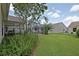 Expansive backyard featuring green lawn, screen enclosure and manicured shrubbery at 3146 Williams Rd, The Villages, FL 32162