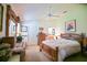 Comfortable bedroom featuring wooden furniture, soft lighting, and access to the Primary bath at 3146 Williams Rd, The Villages, FL 32162