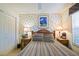 Cozy bedroom features a patterned bedspread, side tables, and natural light at 3146 Williams Rd, The Villages, FL 32162