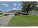 Beautiful single-story home with lush green lawn and brick driveway at 3146 Williams Rd, The Villages, FL 32162
