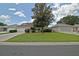 Inviting single-story home with manicured lawn, mature tree, and brick driveway at 3146 Williams Rd, The Villages, FL 32162