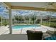 Inviting screened-in pool area with clear blue water, lounge chairs, and a tranquil garden view at 3146 Williams Rd, The Villages, FL 32162