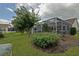 View of the screened-in patio with well maintained green grass in the backyard, offering a serene outdoor living space at 3146 Williams Rd, The Villages, FL 32162
