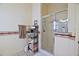 Elegant shower featuring glass doors, decorative border, and convenient towel rack at 3146 Williams Rd, The Villages, FL 32162
