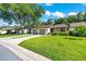 Well-maintained front yard with lush green grass, mature tree, and attached one-car garage at 3707 Ne 17Th St, Ocala, FL 34470