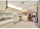 Cozy kitchen featuring white cabinets, tile flooring, and an eat-in counter at 3707 Ne 17Th St, Ocala, FL 34470