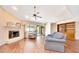Open-concept living room with fireplace, wood floors, ceiling fans, and sliding glass doors to patio at 3707 Ne 17Th St, Ocala, FL 34470