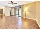 Spacious living area with wood floors, sliding glass doors to the patio, and a stylish floor lamp at 3707 Ne 17Th St, Ocala, FL 34470