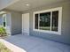 Covered front porch showcasing a large window allowing ample natural light into the house at 5185 Sw 158Th Pl, Ocala, FL 34473