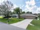 A home with an attached garage, well-maintained lawn, and mature trees providing shade at 5347 Pecan Rd, Ocala, FL 34472