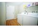 Functional laundry room with washer, dryer, storage shelf, and back door access at 5347 Pecan Rd, Ocala, FL 34472