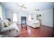 Open living area with wood floors, sofas, ceiling fans, and natural light from large windows at 5347 Pecan Rd, Ocala, FL 34472