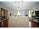 Spacious living room with hardwood floors, sofas, a television, and an open layout to other rooms at 5347 Pecan Rd, Ocala, FL 34472