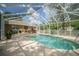 Beautiful screened pool is surrounded by lush landscaping and an outdoor kitchen, creating a private backyard retreat at 5347 Pecan Rd, Ocala, FL 34472