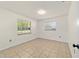 Bright bedroom with tiled floor and two windows offering a view of the outdoors at 5500 Se 2Nd Pl, Ocala, FL 34480