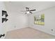 Carpeted bedroom featuring a ceiling fan, window, and white walls at 5500 Se 2Nd Pl, Ocala, FL 34480