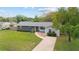 Well-maintained single-story home with mature landscaping, a walkway, and a spacious driveway at 5500 Se 2Nd Pl, Ocala, FL 34480