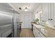 Galley kitchen featuring stainless steel appliances, white cabinets, and a stylish countertop at 5500 Se 2Nd Pl, Ocala, FL 34480
