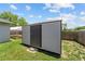 Backyard storage shed with a metal door and concrete steps at 5500 Se 2Nd Pl, Ocala, FL 34480