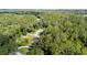 An aerial view of a home with an above ground pool in a wooded neighborhood at 6 Sequoia Loop, Ocklawaha, FL 32179