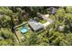 Aerial view of the property showcasing the house, pool, fenced yard, and surrounding trees at 6 Sequoia Loop, Ocklawaha, FL 32179