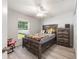 Relaxing bedroom with a wooden bed frame, dresser, and ample natural light from the window at 6 Sequoia Loop, Ocklawaha, FL 32179