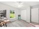 Bright bedroom featuring wood floors, a window with a view to the outdoors, and white closet doors at 6 Sequoia Loop, Ocklawaha, FL 32179