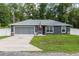 Charming single-story home with a well-maintained lawn and a two-car garage at 6 Sequoia Loop, Ocklawaha, FL 32179