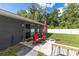 Outdoor patio area with red chairs, an umbrella, and a view of the backyard at 6 Sequoia Loop, Ocklawaha, FL 32179