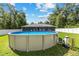 Backyard featuring an above-ground pool surrounded by a white fence and lush green grass at 6 Sequoia Loop, Ocklawaha, FL 32179